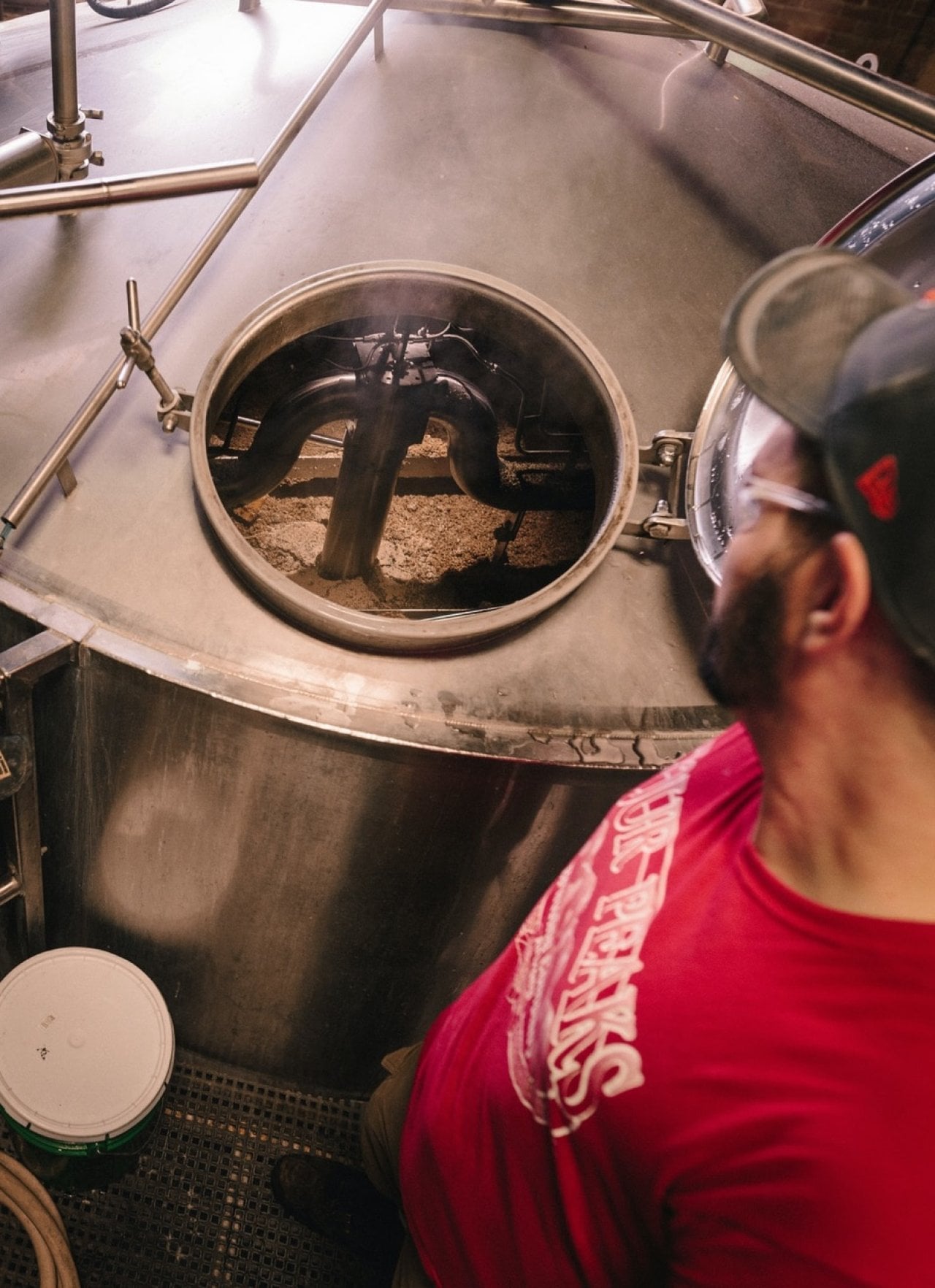 Bierbrouwer die kijkt in een vat